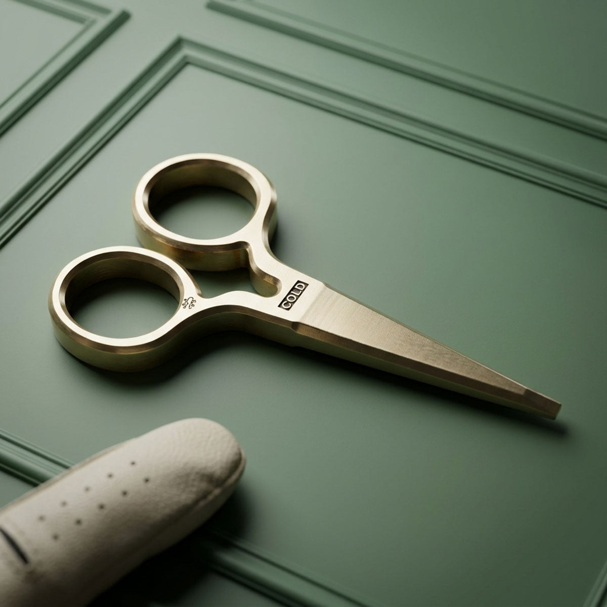 Solid brass King Cold pitch tool with COLD milled at the pivot, brushed satin finish, resting on green paneled surface