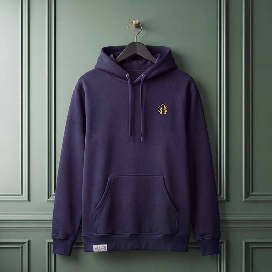 Navy blue Bench Sketch hoodie hanging on a black hanger against a dark green paneled wall, featuring yellow embroidered logo on front chest