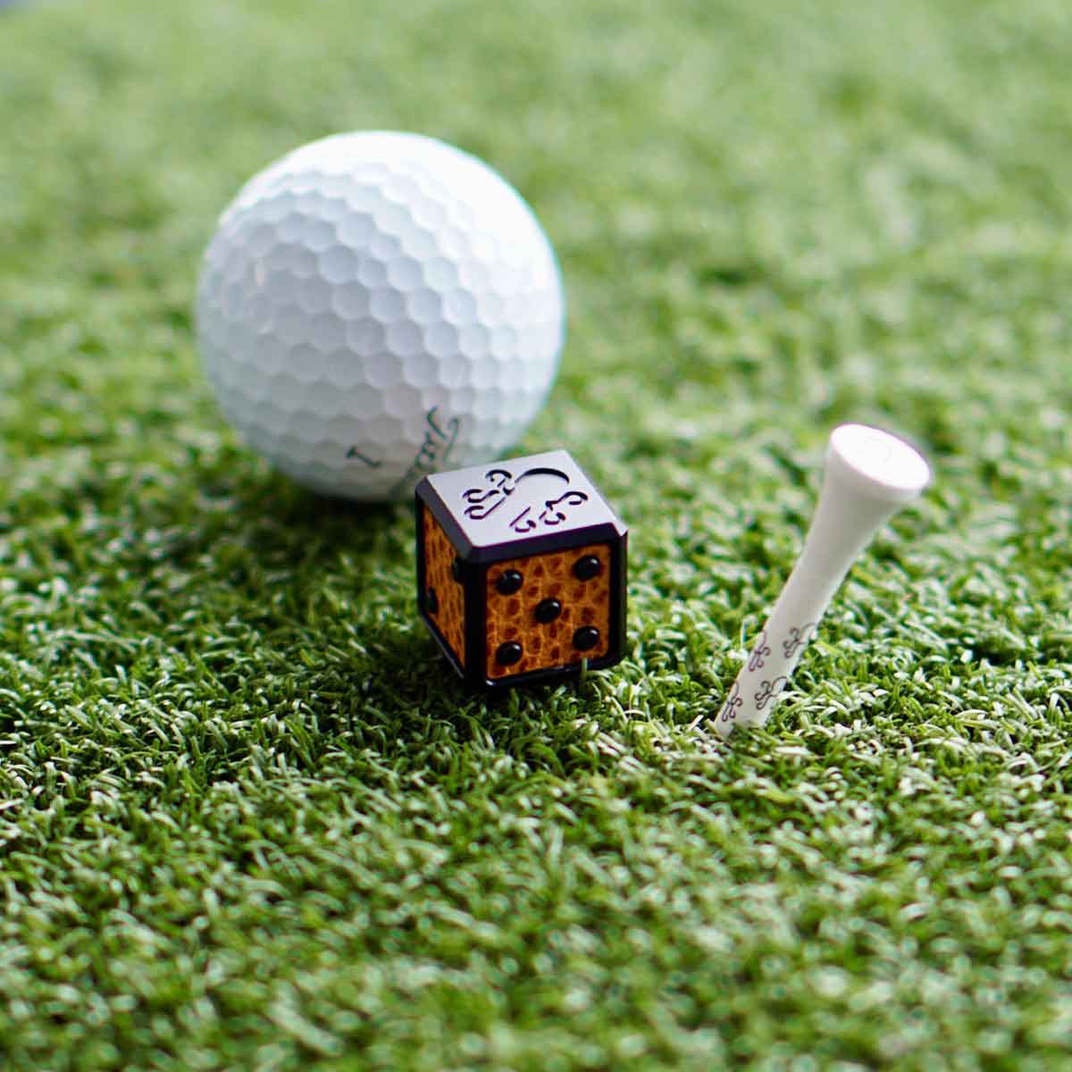 Black anodized aluminum die marker with camel leather inlay on one face