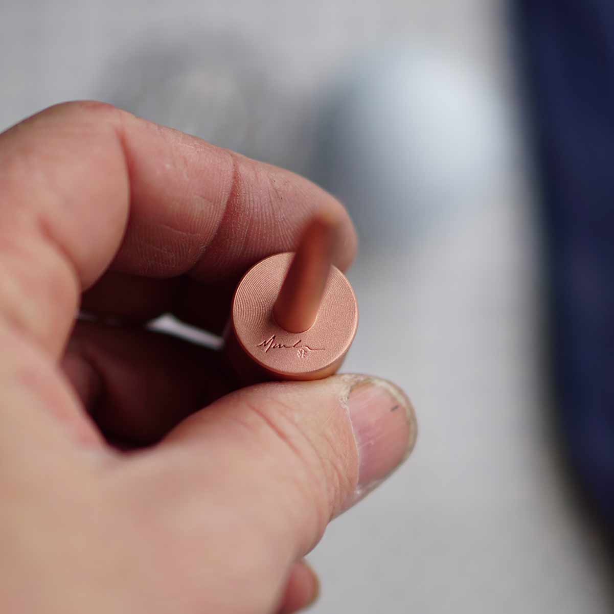 One-piece copper golf pitch tool featuring Marc Cordeira's signature at the base