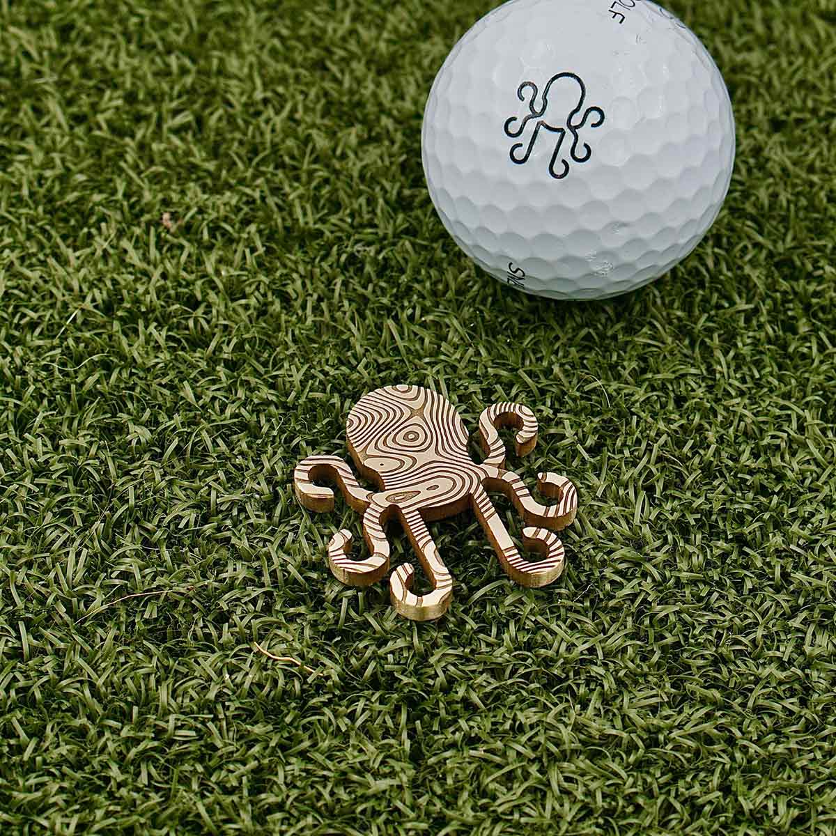 Golf ball marker inspired by the mythical Kraken, dual-sided etching