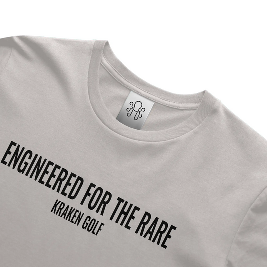 Kraken Golf gray t-shirt featuring the phrase "Engineered for the Rare" printed in bold black Oswald font across the chest.