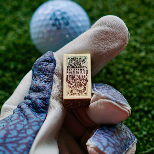 Bottom of brass Brix marker engraved with coiled mamba snake and the phrase Mamba Mentality in blackened hatch lines