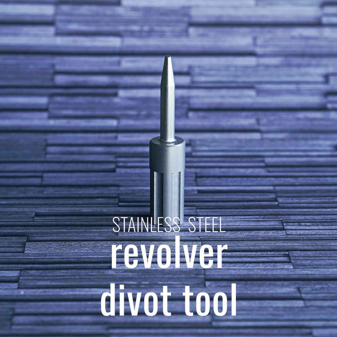 The stainless steel revolver golf pitch tool on a gray background.