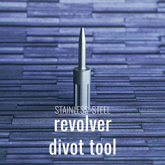 The stainless steel revolver golf pitch tool on a gray background.