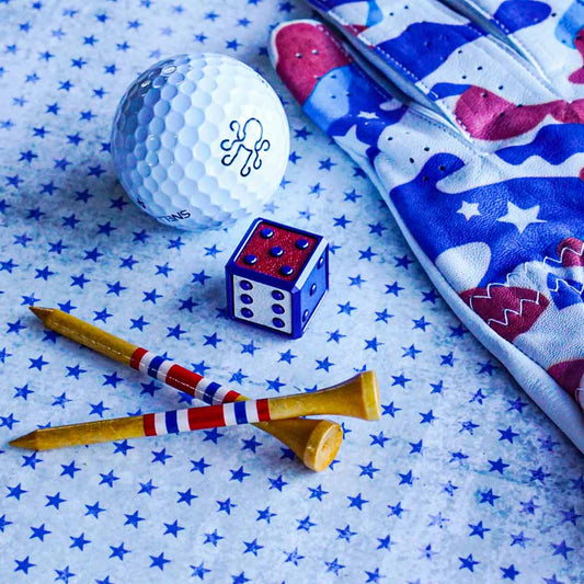 A royal blue cube-shaped golf ball marker with red, white, and blue leather inlays. Limited edition Kraken Golf die crafted for the 4th of July.