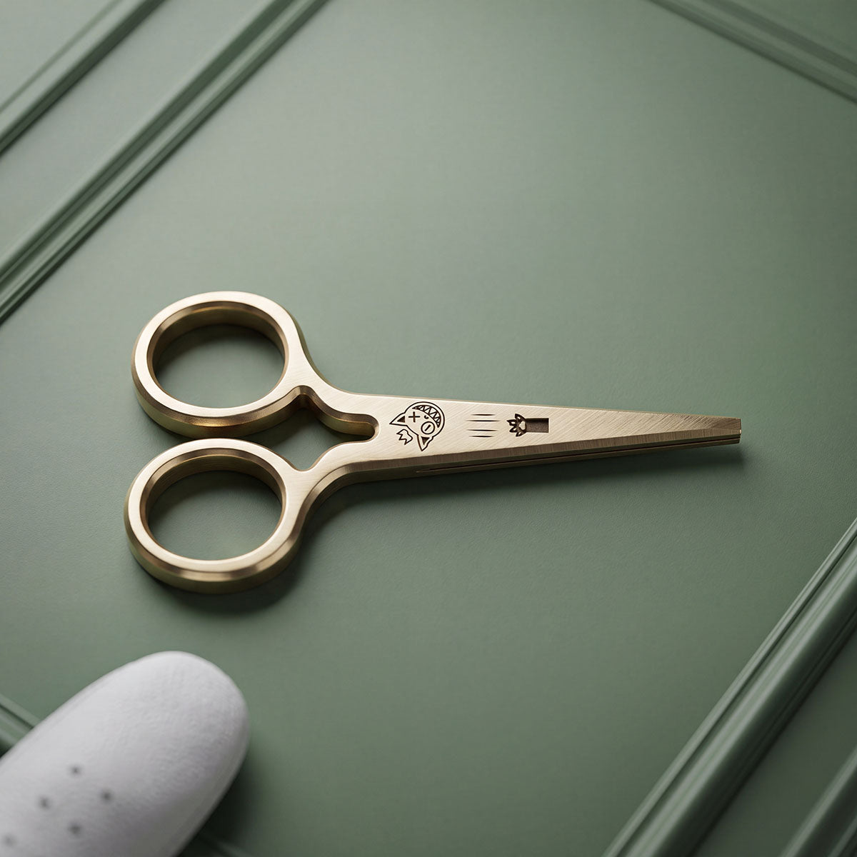 Brushed brass scissor-form golf pitch tool engraved with a crowned King Cold cat head and crown mark on the blade face