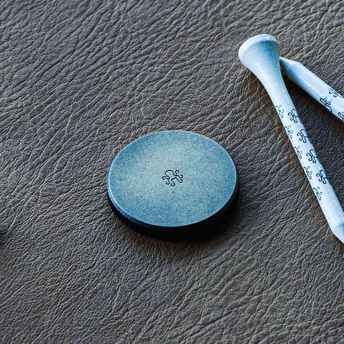 Arc Revenant brass marker backside with centered Kraken logo on darkened satin finish.