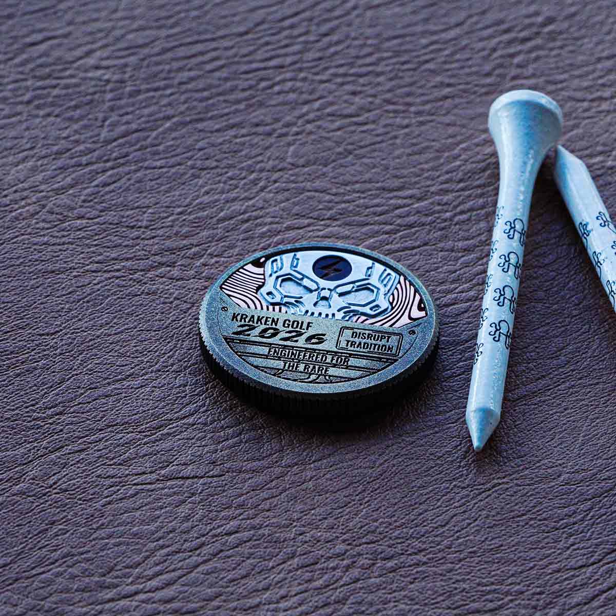 Arc Revenant ball marker with copper Damascus inlay and aluminum skull with lightning enamel.