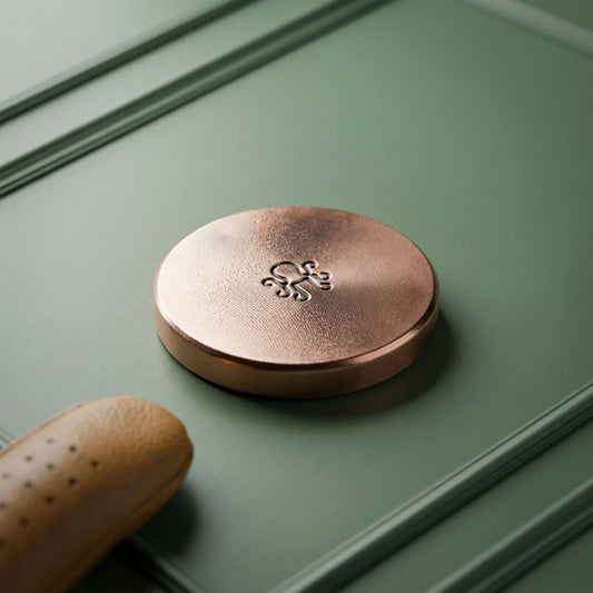 Reverse of the BEDROCK copper golf ball marker showing raw mill finish and struck Kraken mark