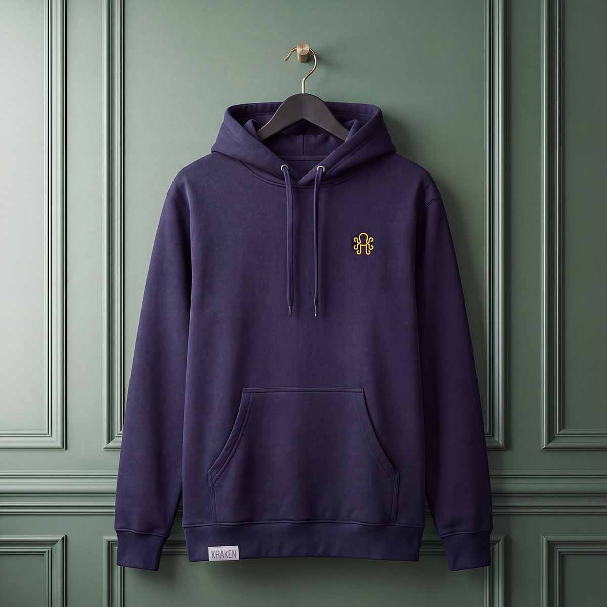 Navy blue Bench Sketch hoodie hanging on a black hanger against a dark green paneled wall, featuring yellow embroidered logo on front chest