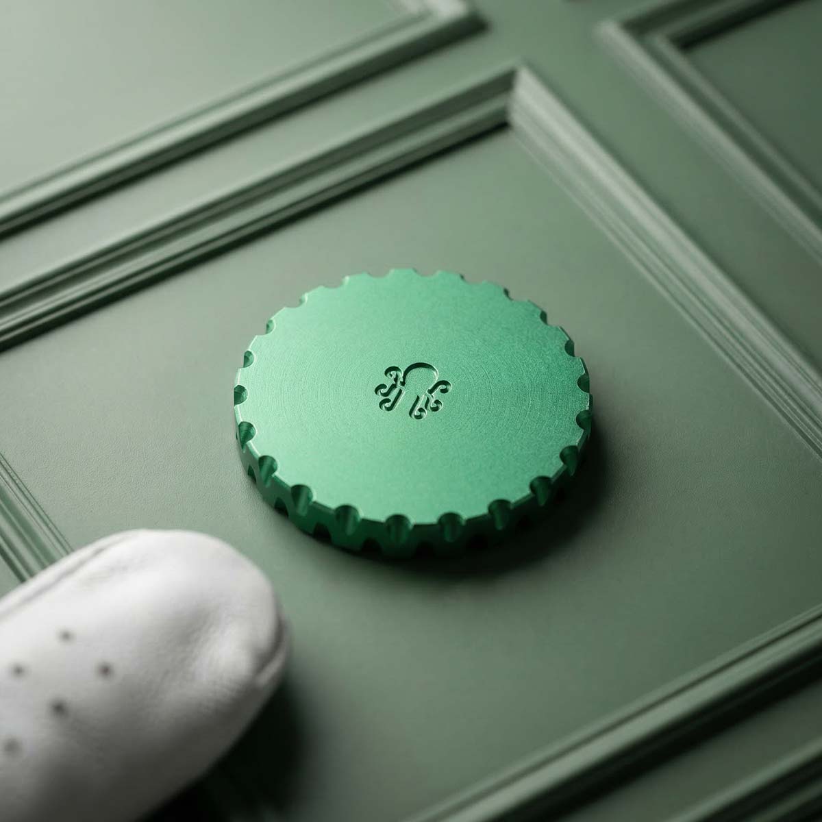 Green anodized aluminum golf ball marker with shamrock inlay