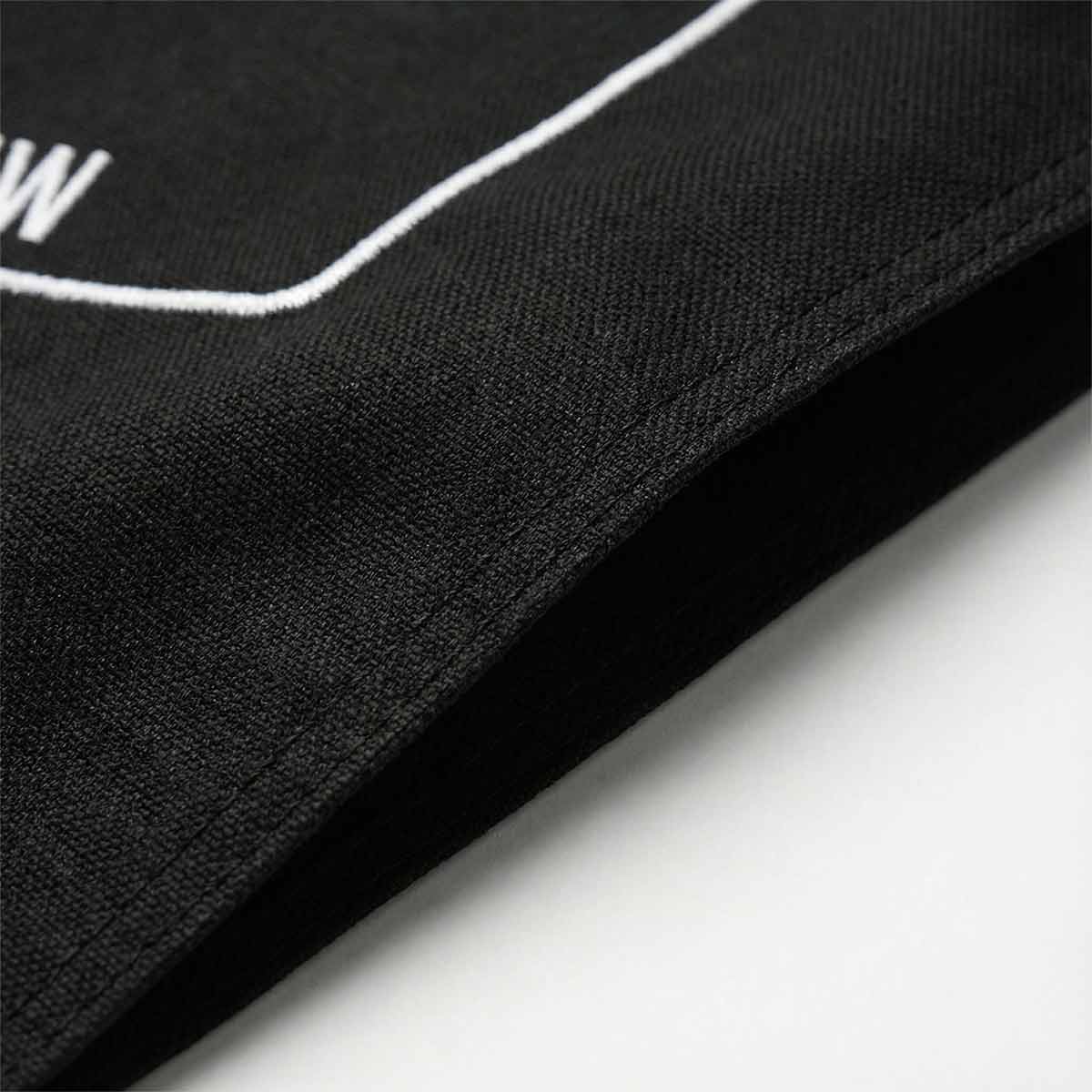 Black fabric with white stitching detail on a white background