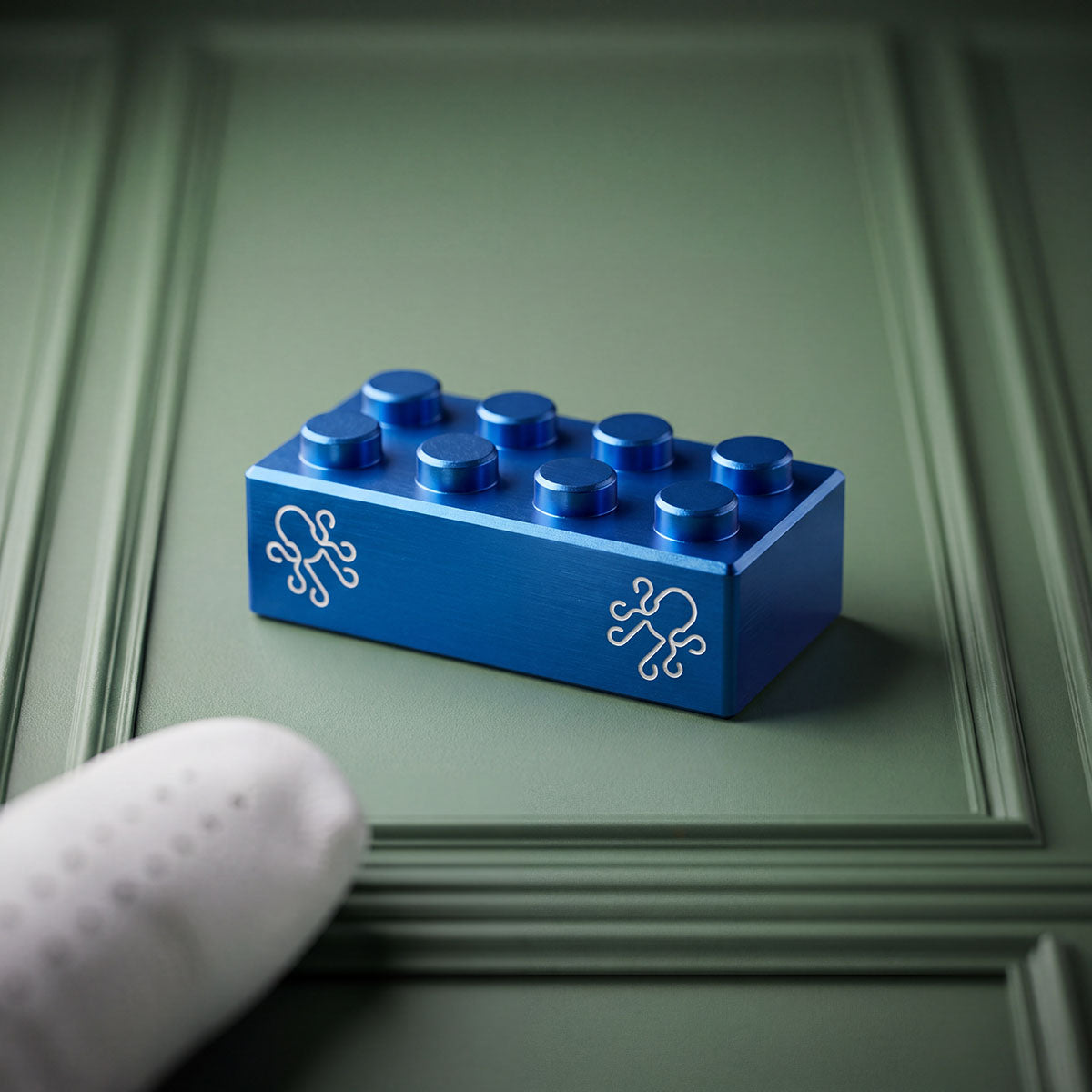 Blue Brix golf ball marker in hard-anodized cobalt 7075 aluminum, sculpted brick form