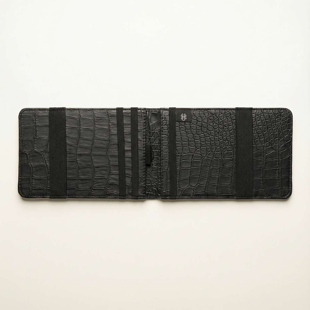 Black crocodile-patterned inerior of the golf yardage book on a white background