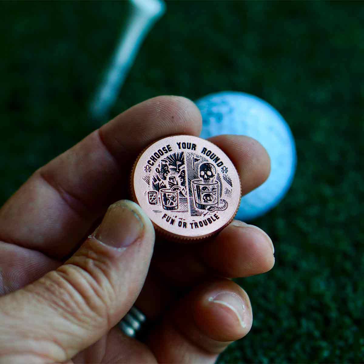 Dual-sided copper golf marker showing drink scene on one side and Fun or Trouble engraving on the other