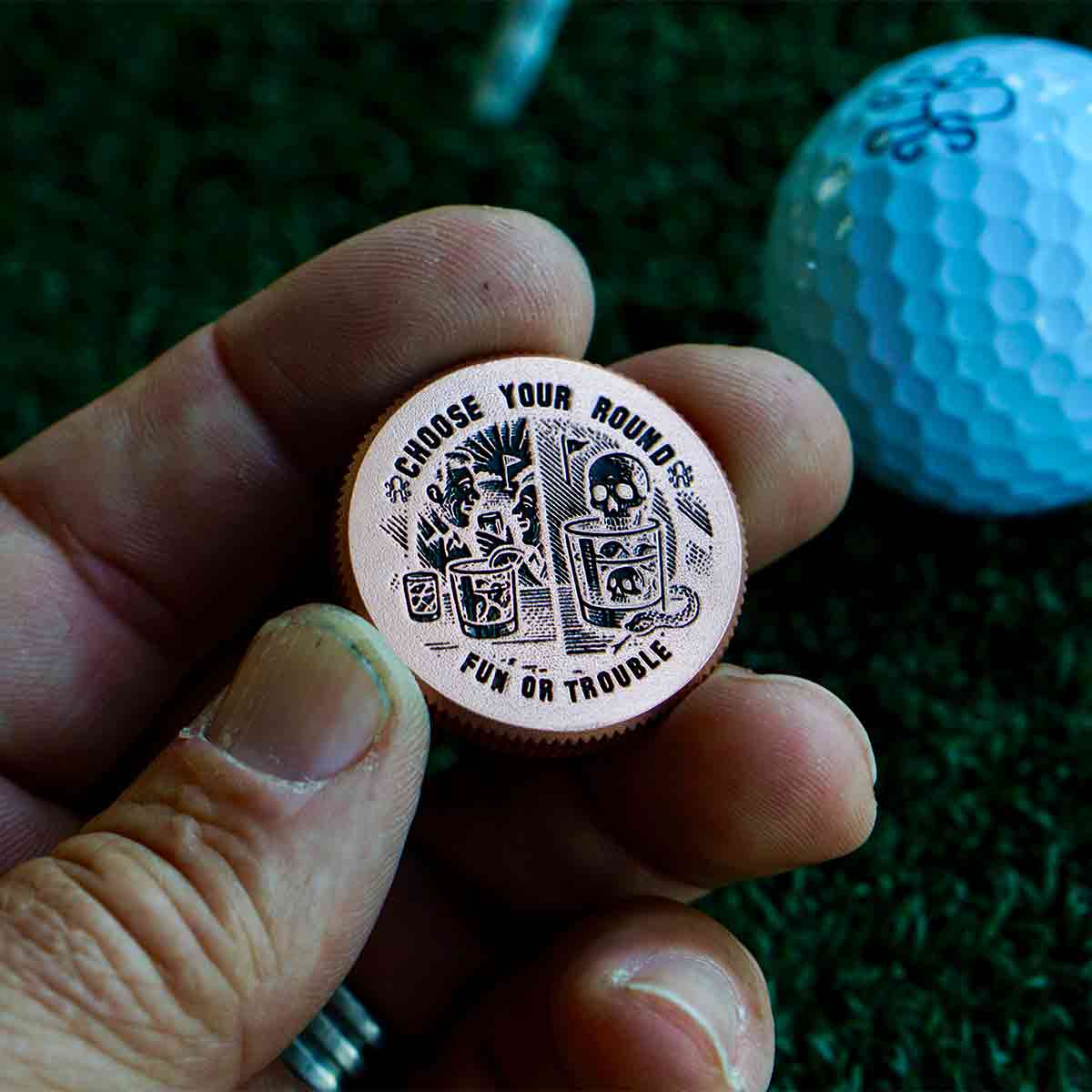 Close-up of Fun or Trouble engraved back on copper golf ball marker