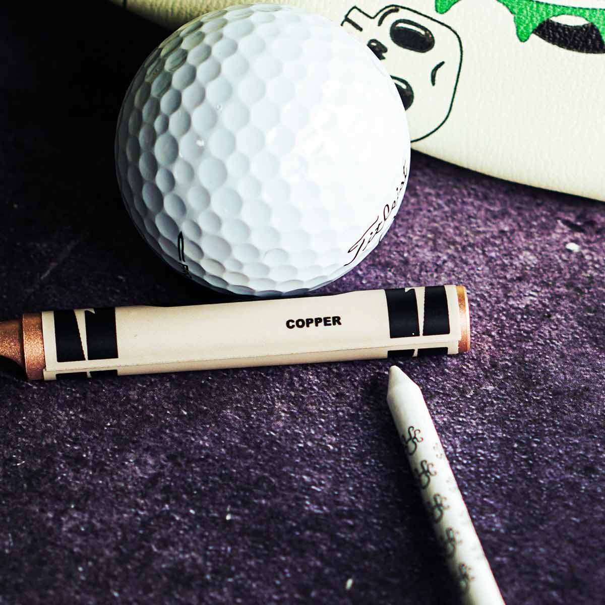 Kraken Golf copper divot tool shaped like a crayon with natural patina