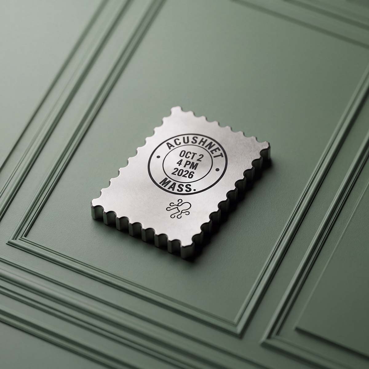 Reverse of the FACE VALUE titanium ball marker, raw titanium engraved with a round Acushnet, Mass. postmark dated Oct 2 2026.