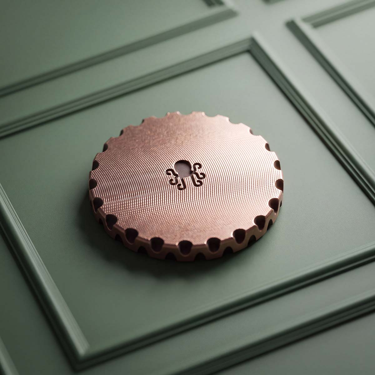 Back of Hare's Breadth copper golf ball marker showing scalloped EDC edge and centered Kraken logo