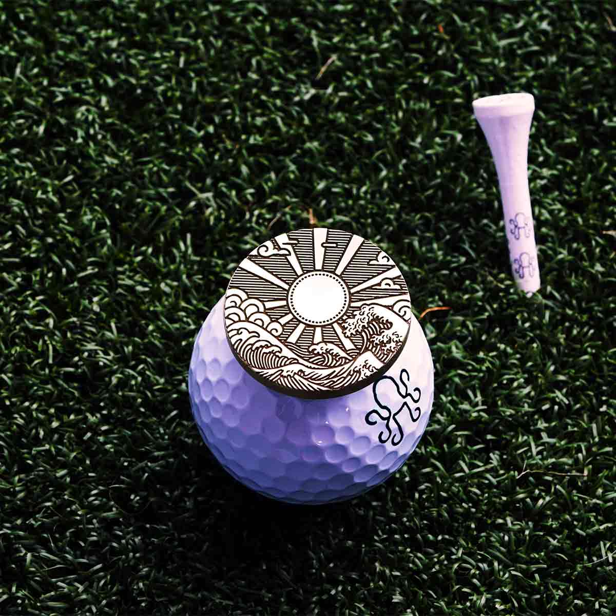 Brass Hinode Legacy golf ball marker featuring engraved Japanese wave, cloud, and rising sun design