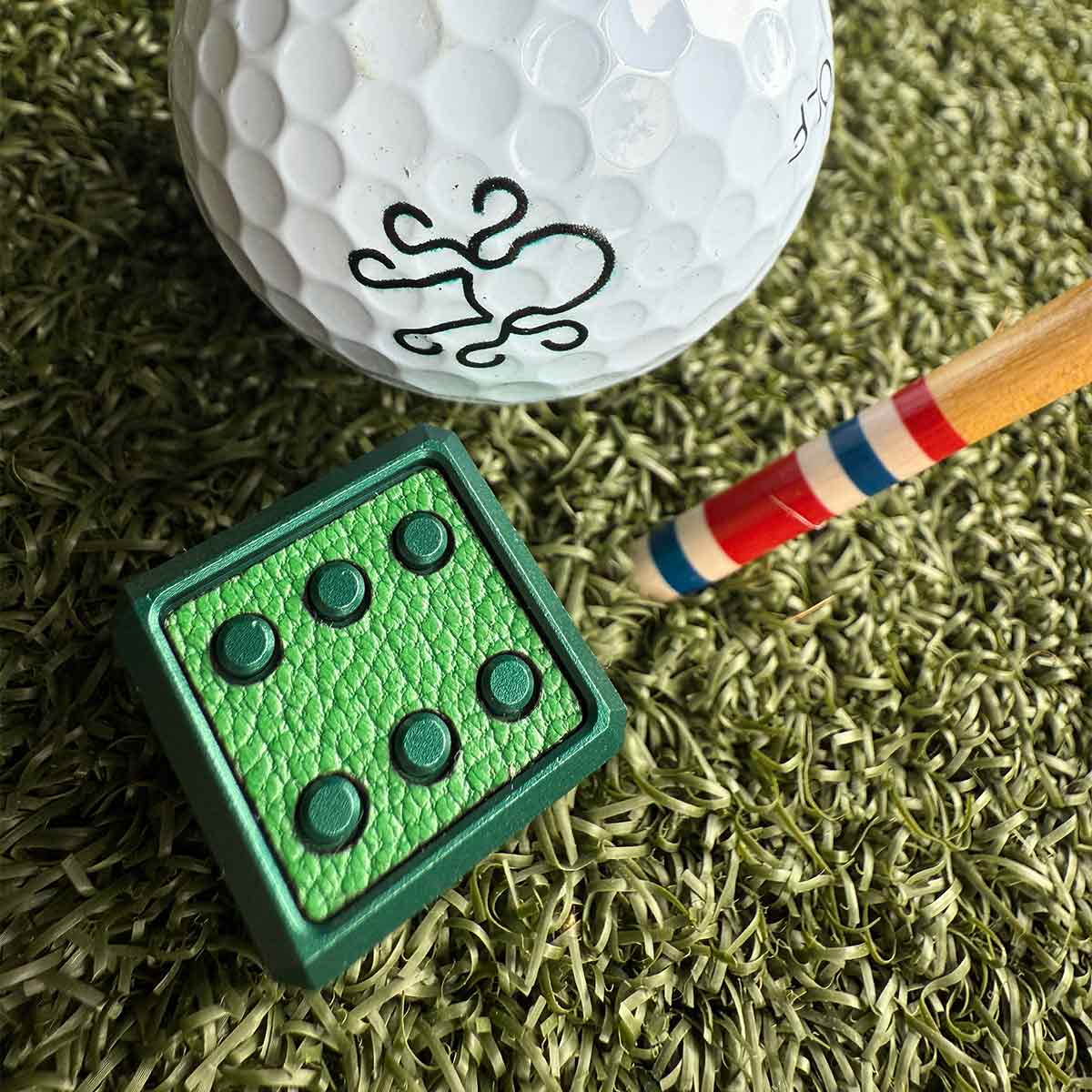 Collector's edition golf ball marker in emerald green with textured leather inlays. Precision milled and laser-engraved by Kraken Golf.