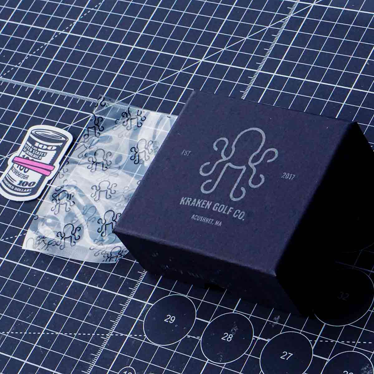Black box with 'Kraken Golf Co.' branding on a grid surface