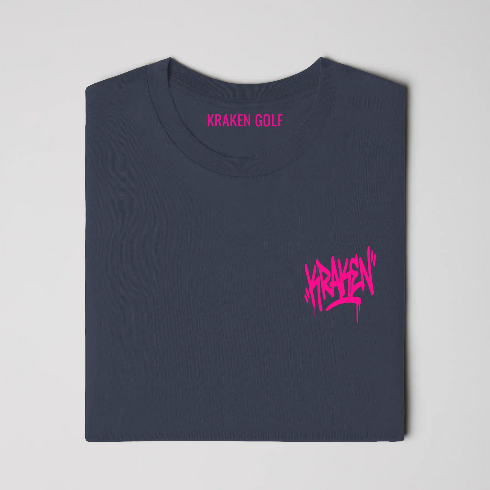 Left chest detail of the navy Origin tee showing the black Kraken graffiti tag on heavyweight garment-dyed cotton