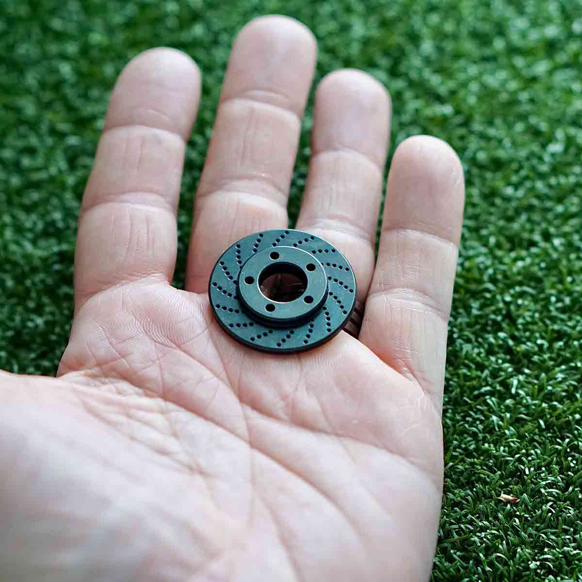 Rotor-inspired golf marker with deep industrial finish