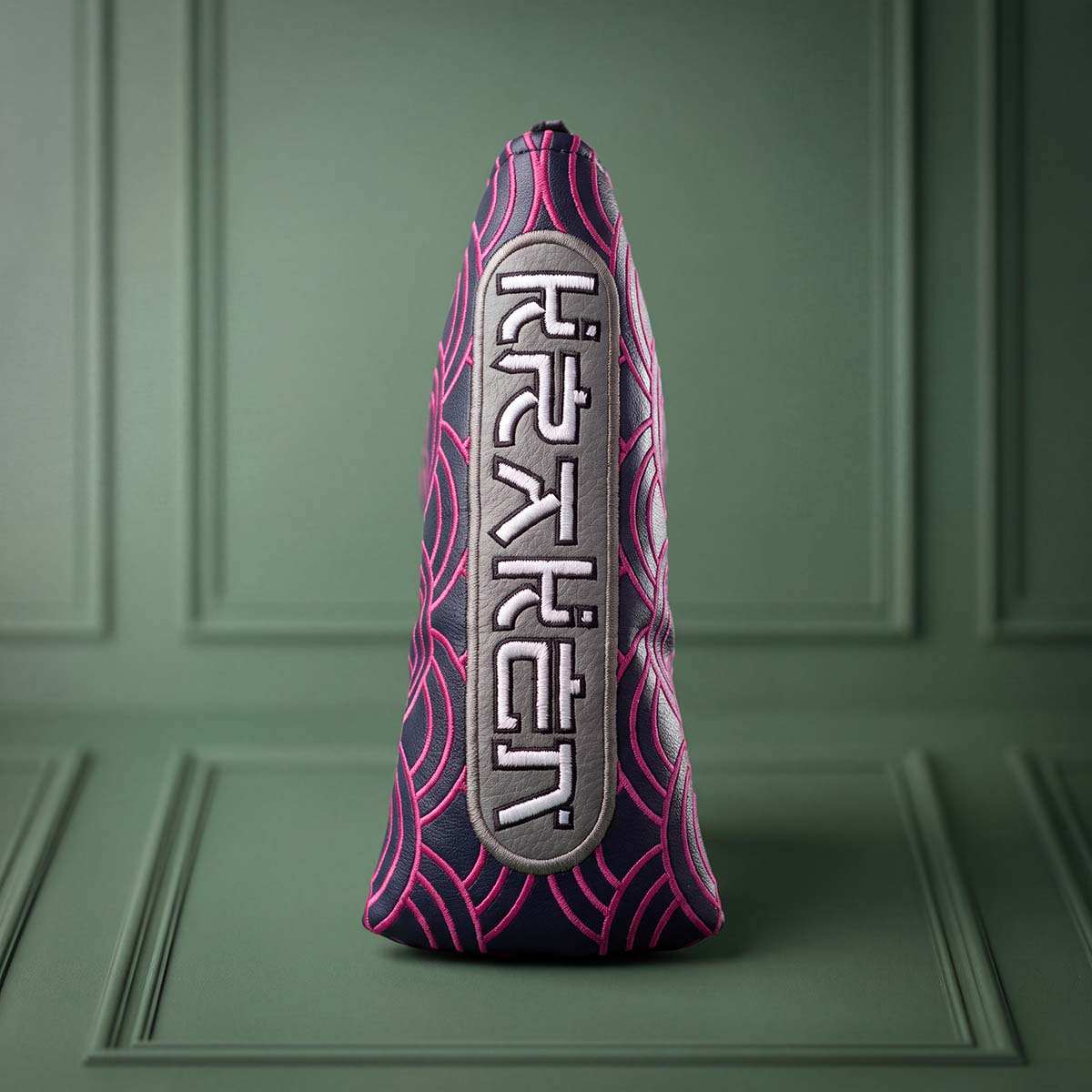 Angled view of navy and pink Seigaiha blade putter headcover showing wave embroidery and toe badge