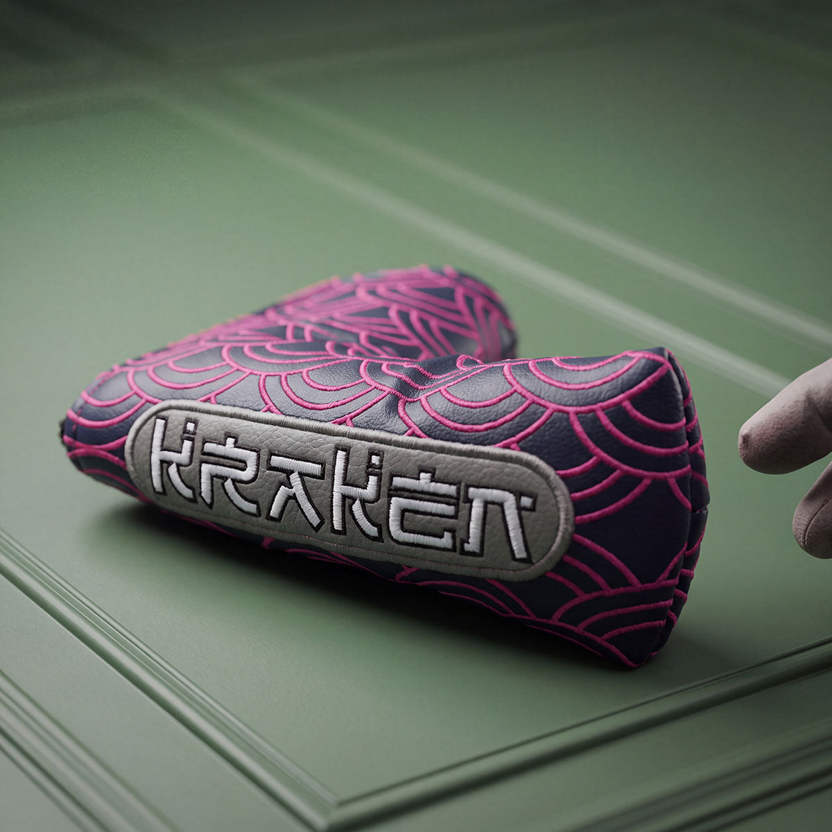 navy blade putter headcover standing upright with hot pink embroidered Seigaiha Japanese wave pattern and silver KRAKEN badge, Kraken Golf