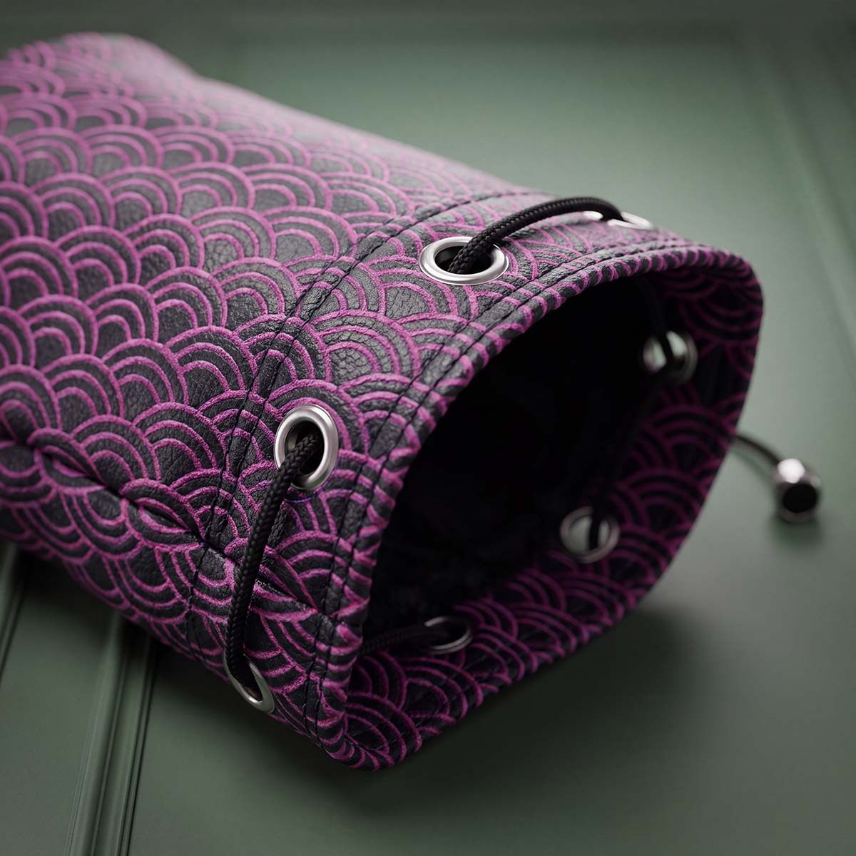 Close-up of navy Seigaiha valuables bag opening showing pink wave embroidery and black plush interior