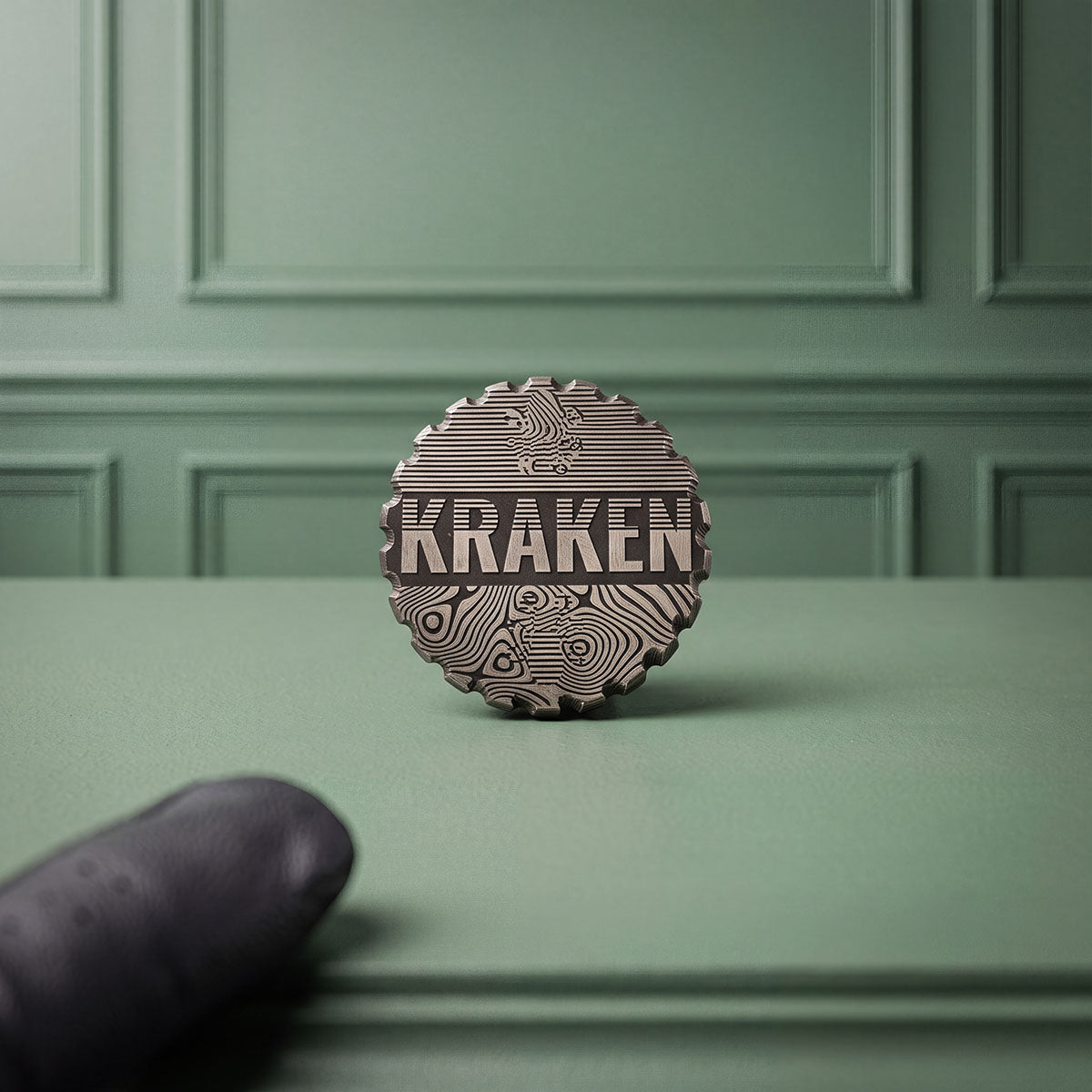 LIBERTY ball marker reverse — laser-marked KRAKEN wordmark over contour linework on black oxide stainless steel