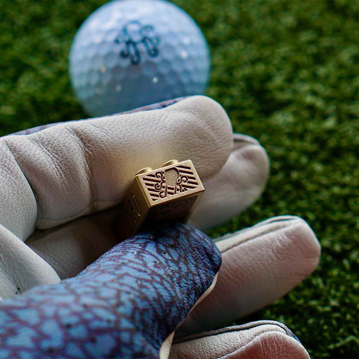 Close-up of end face featuring deeply hatched Kraken logo engraving in brass