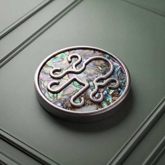 NACRE golf ball marker with iridescent abalone shell inlay and raised stainless steel Kraken logo