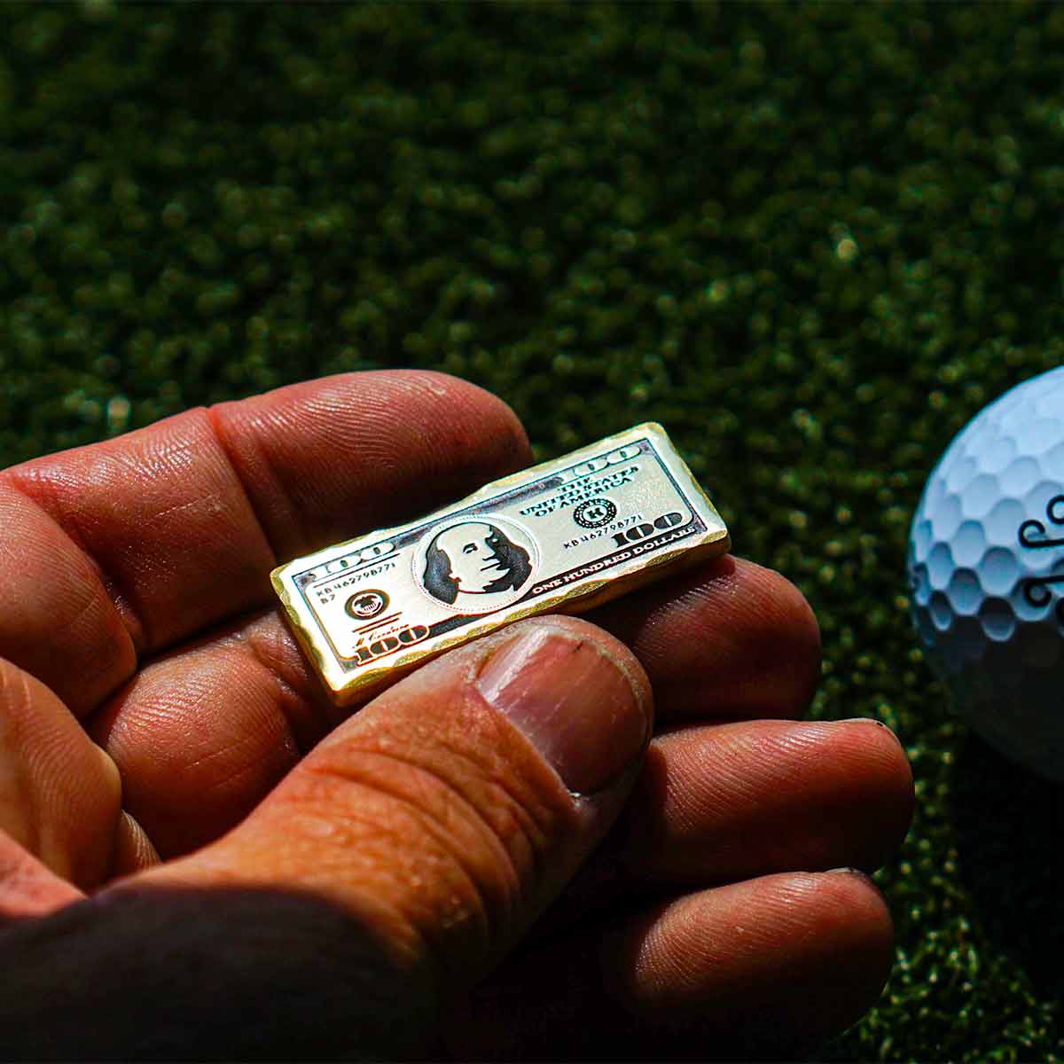 Blackened brass $100 bill golf ball marker with matte patina finish