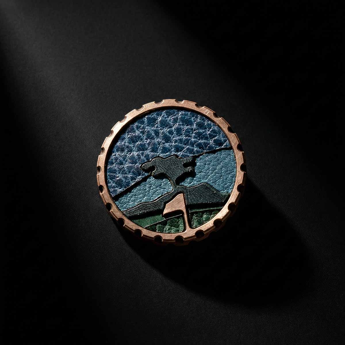 Macro photo of copper ball marker with black tree center inlay and leather logo segments