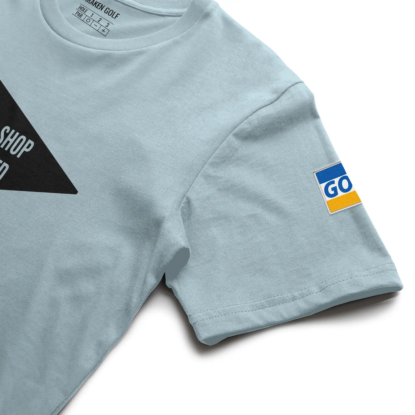 Left sleeve detail of the Pro Shop Rejected golf tee — visa-style green and gold ACUSHNET credential patch by Kraken Golf Co.