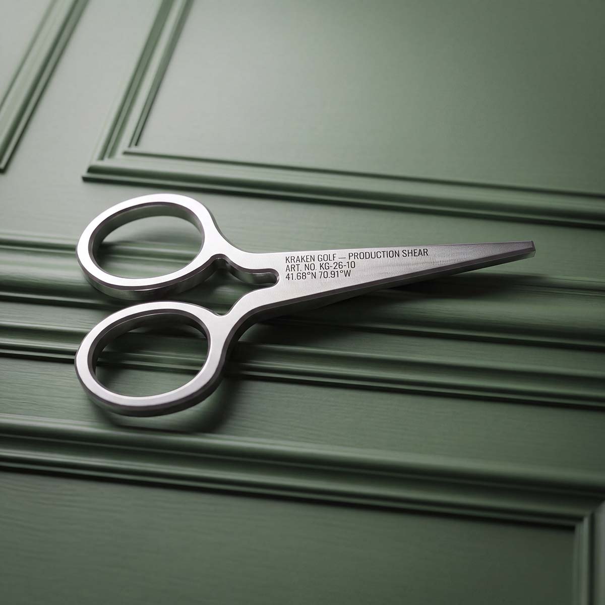 Back of Production Shears pitch tool showing laser-engraved Kraken Golf logo on brushed stainless steel