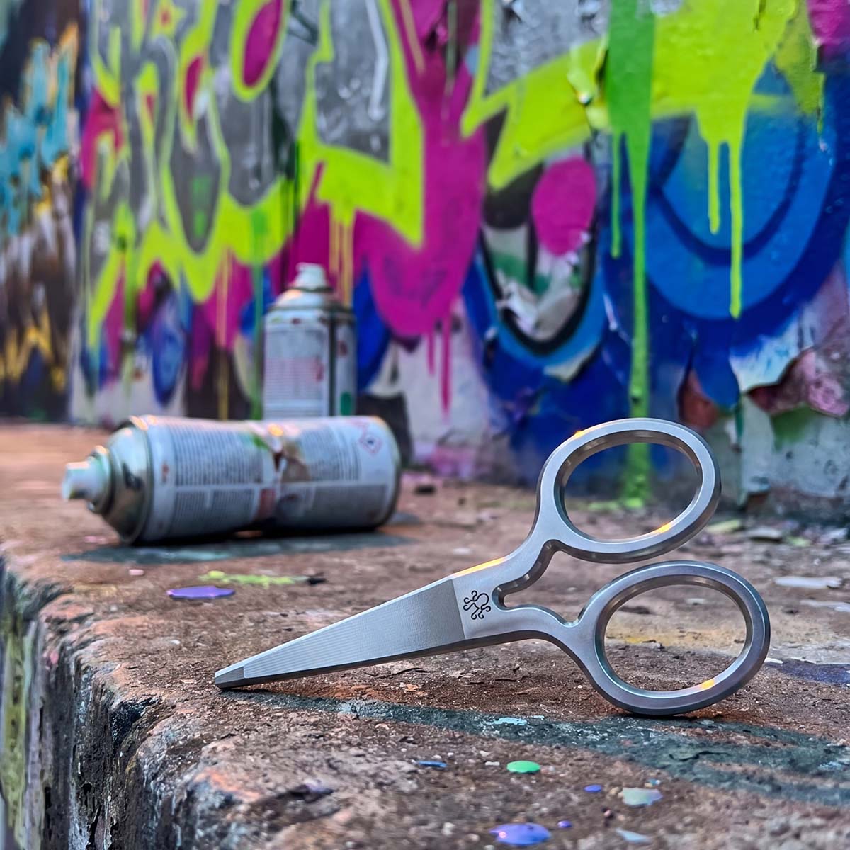 Production Shears stainless steel pitch tool repairing a ball mark on graffiti background. 