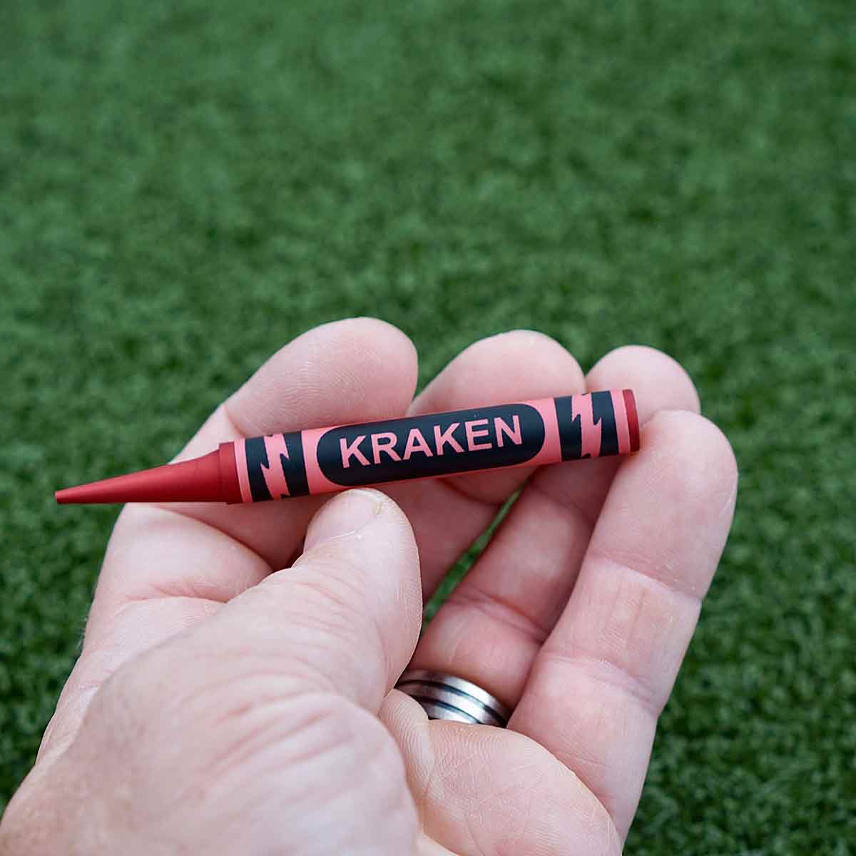 Crayon-style golf divot tool with waterproof label and bold red finish