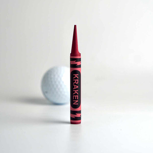 Red Birdie Crayon Divot Tool in red anodized aluminum, shown on putting green