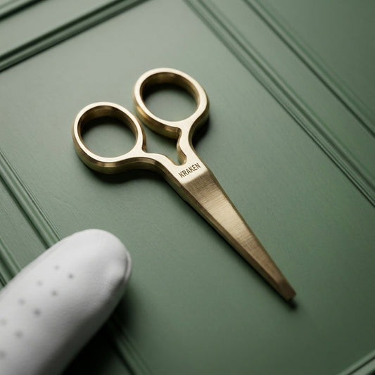 Oswald KRAKEN wordmark micro-engraved on brushed brass pitch tool finger loops