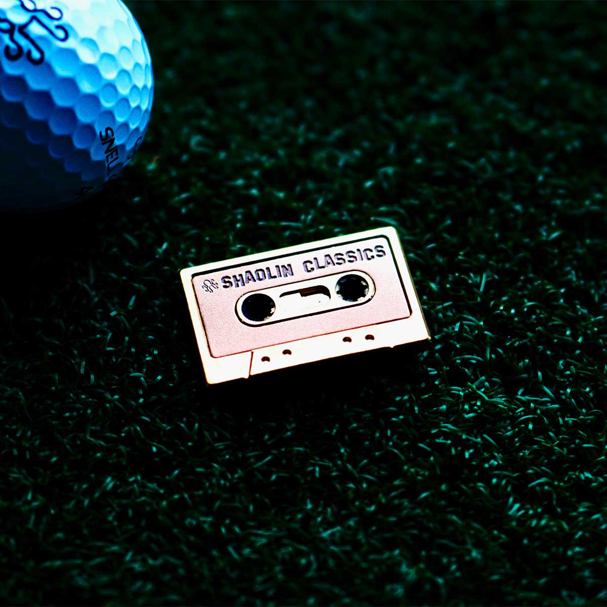 Close-up of copper inlay reading SHAOLIN CLASSICS on golf ball marker