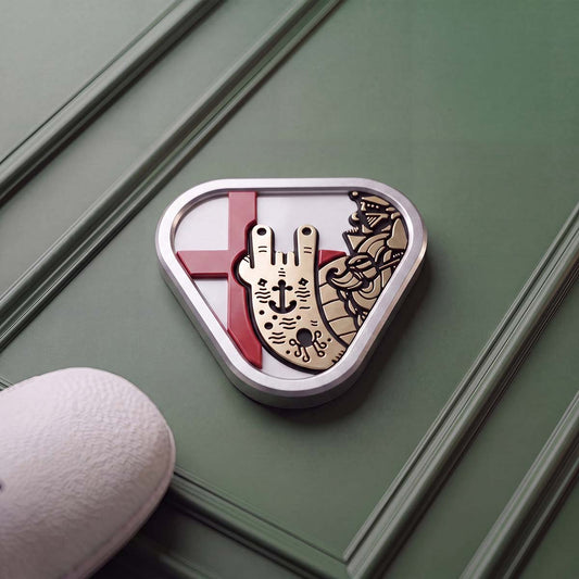 Triangular stainless steel golf ball marker with a polished brass Captain figure throwing horns over the red cross of England on a white inlay.