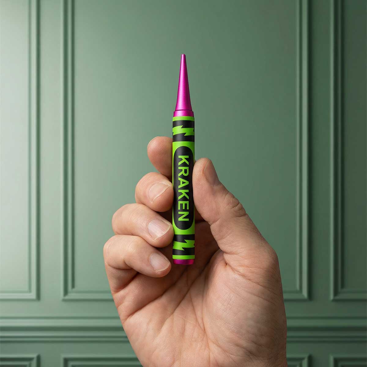 Hand holding a Kraken Slice Free Crayon Pitch Tool against a green background