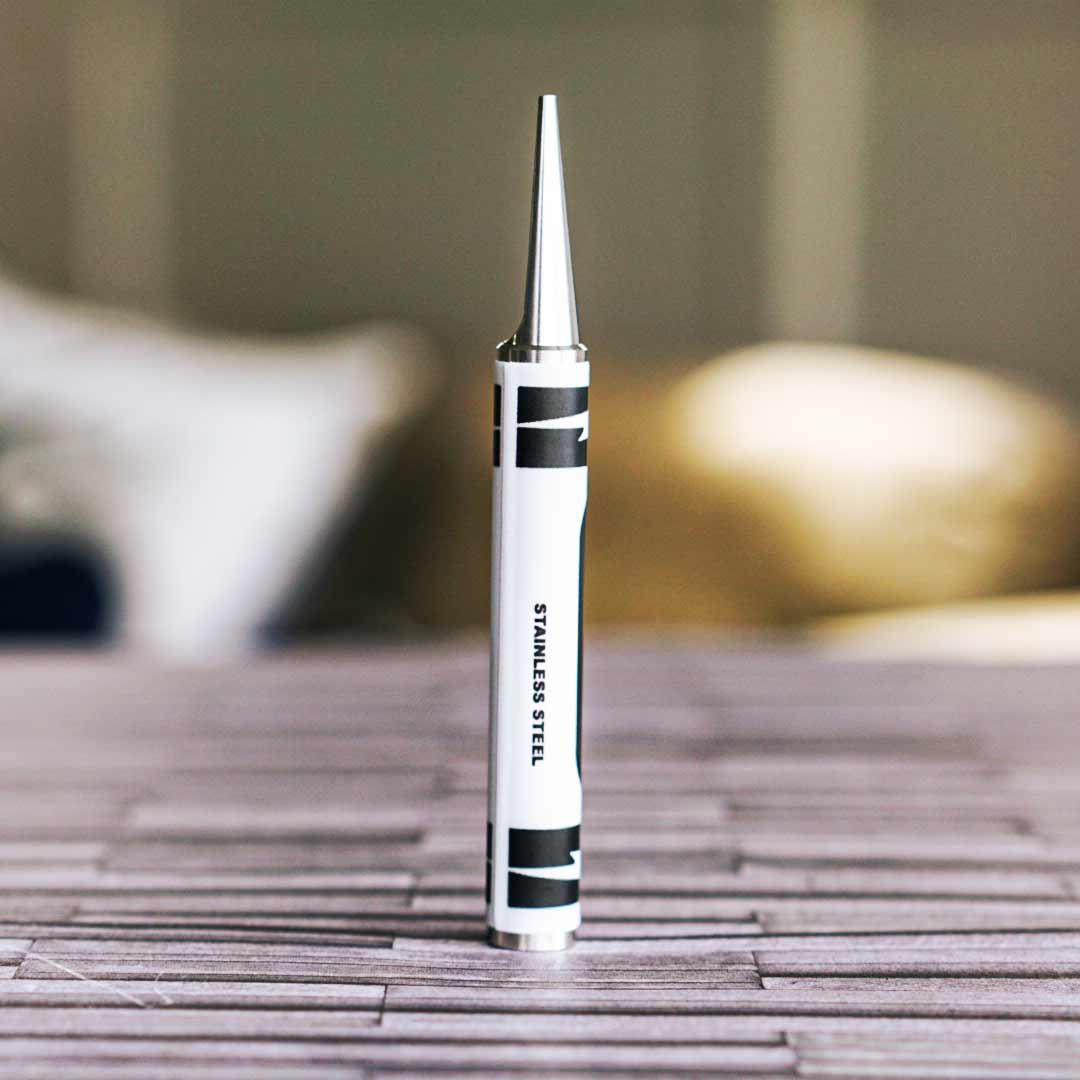 Stainless steel crayon-shaped golf divot tool on a golf table