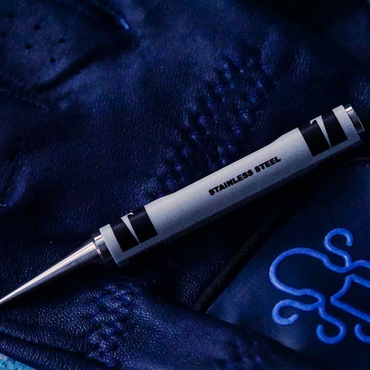 Stainless Steel Crayon Pitch Tool on a navy blue golf glove