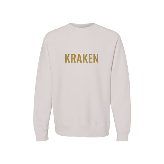 Brass KRAKEN wordmark printed across the chest of a bone-colored heavyweight crewneck sweatshirt
