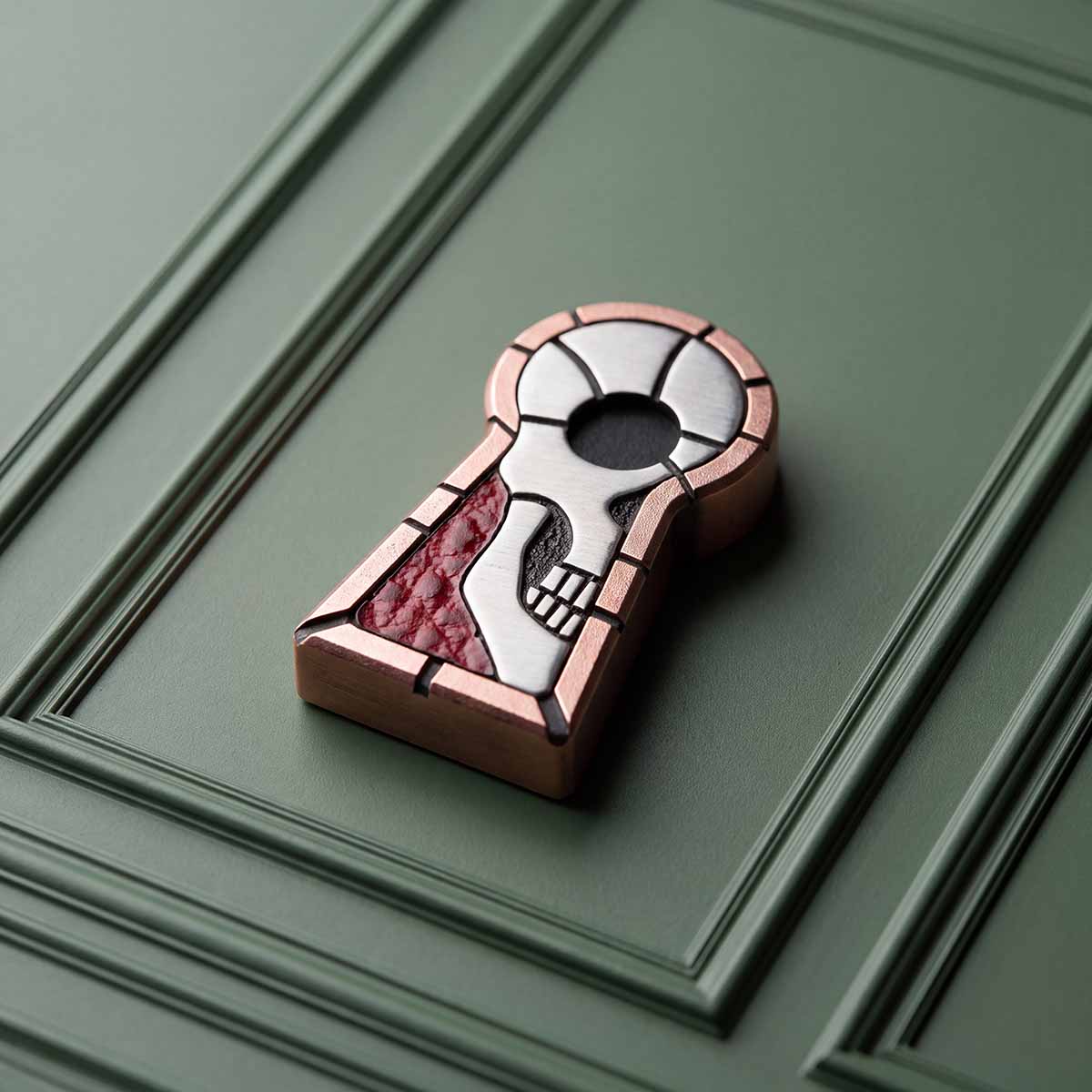 The Keep keyhole-shaped copper golf ball marker with stainless steel skull and Dollaro red leather inlay